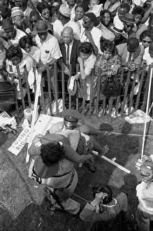 Enforcement: A crowd of African Americans behind a fence