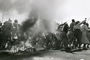 Assegais: A crowd of chanting men and woman, some armed