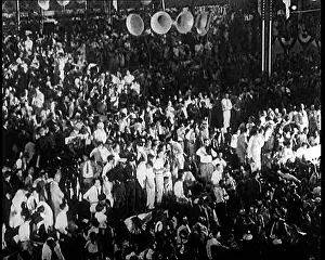 Gathers: A Crowd Gathers in an Auditorium to Listen to Speeches