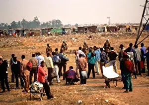 Squatter: Crowd, some with possessions in wheelbarrows