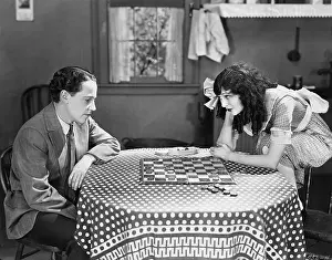 Checker: Cuople playing checkers or draughts