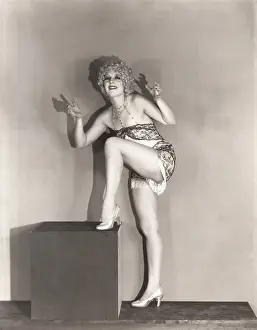 Sensuous: Dancer posing with her leg up on large wooden block