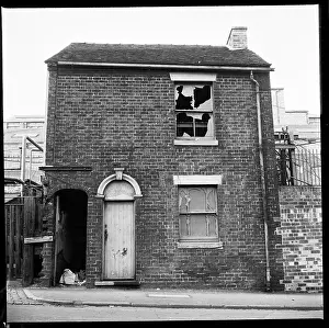 Burslem: A derelict house with industrial complex in the background