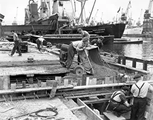Robin Adler: Dockside scene with vessels and men at work, London