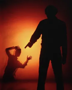 Unlawful: Dramatic Silhouette of Anonymous Man Aiming Pistol