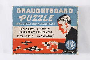 X100498: Draughtboard puzzle game, man playing game