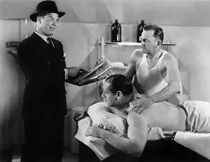 Massaging: Well dressed man reading to a man who is getting a massage