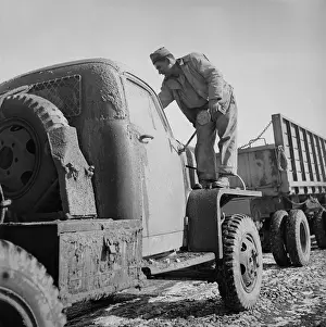 Old Fashion: The driver is cleaning mud from the windshield