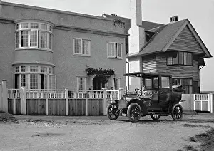 Clapboard: Early car parked in front of house