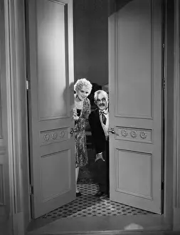Peeking: Elderly couple peek through doors