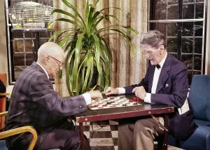 Checkers: Two Elderly Men Playing a Game of Checkers in Lounge