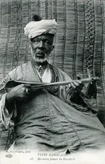 Plucked: Elderly Moroccan man of the Gnawa playing a sintir
