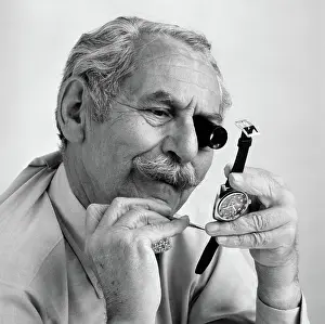 Watchmaker: Elderly mustached man with loupe on eye & small
