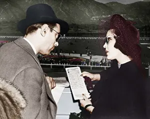 Inquire: Elegant couple at a horse race looking at a program