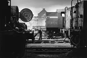 Barrow: Nine Elms Loco Yard with worker with barrow between locos