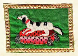 Sampler: Embroidered dog on a cushion with gold edging