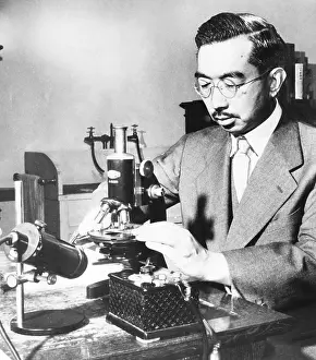 Respected: Emperor Hirohito puts specimens on a slide under