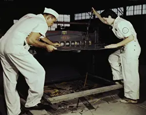 Servicing: Employees work a cutting machine at Naval