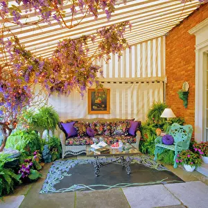 Domicile: Enclosed Patio with Wicker Sofa Table Flowers