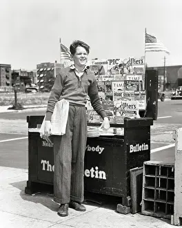 Newsstand: Enterprising Boy Standing by Newspaper and Magazine