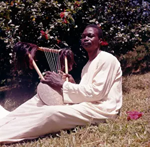 Lyres: Evasto Muyinda playing endongo string lyre, Boys at