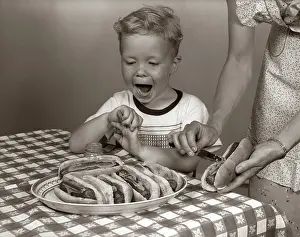 Frankfurters: Excited boy at table with checkered tablecloth