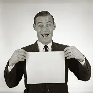 Crr001: Excited businessman looking at camera holding