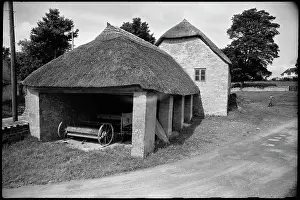 Backgroundthe: Exterior view of a single-storey thatched barn