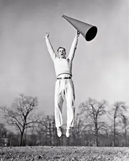 Exuberant: Exuberant Young Man Jumping and holding a Megaphone