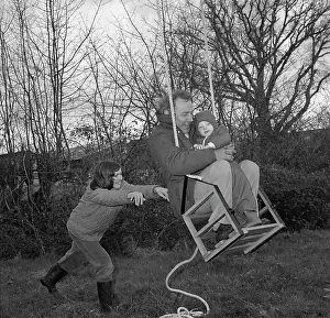 Tony Boxallfrps: Family in a garden playing on a swing