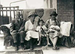 Sepia Images: Family group on a sofa on a verandah