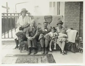 Sepia Images: Family group on a sofa on a verandah