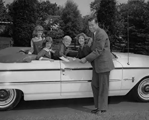 Pausing: Family looking at a map while sitting in a convertible