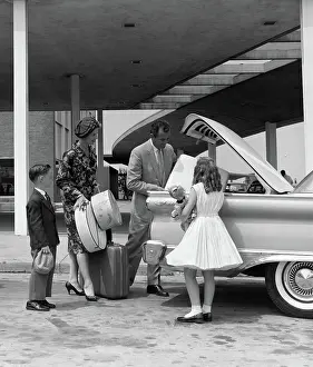 Unpacking: Family of four packing automobile trunk with