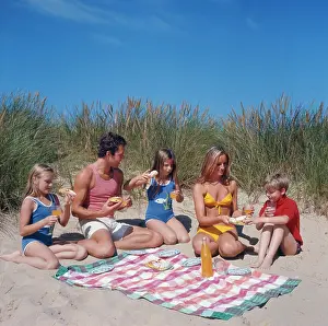 Tanned: Family of five with picnic on beach