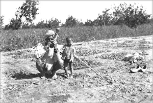 Ponsonby: Father and child in a field, India