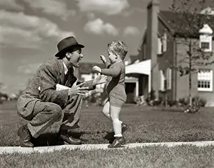 Businesspeople: Father greeting son running towards him on sidewalk