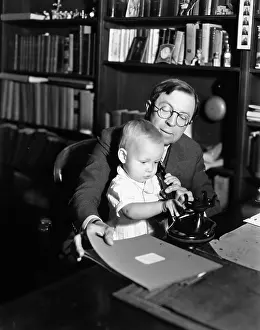 Paternal: Father helping baby use telephone