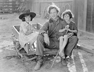 Chuckling: Father sitting with his two daughters on a small