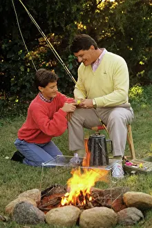 Lures: Father and son by campfire working on fishing
