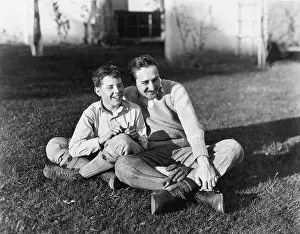 Dads: Father and son sitting together on the grass in