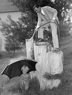 Paternal: Father and toddler playing with hose outside