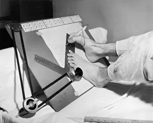 Drafting: Feet of a disabled man using a drafting board