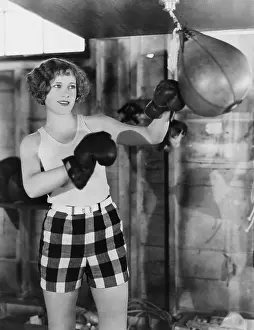 Workout: Female boxer using punching bag