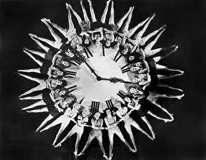 Coordinate: Female dancers circling huge clock