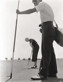 Ov1606: Female golfer and her caddy
