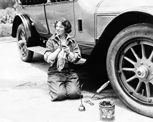 Wiping: Female mechanic changing flat tire