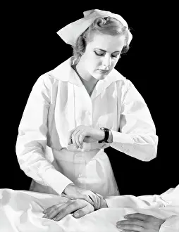 Providers: Female Nurse Checking Patient's Pulse