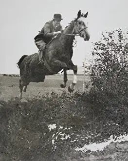 Risborough: Female rider jumping over a moat