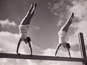 Handstands: Two females handstands on beam